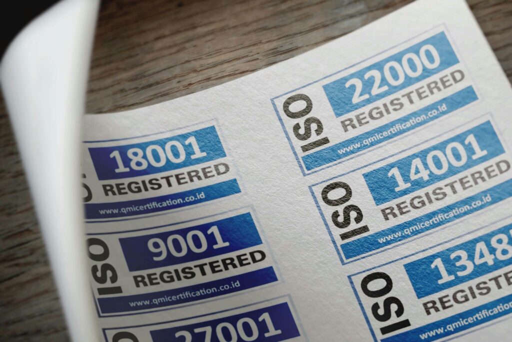 pexels-photo-12324202-12324202 ISO certification stickers with registration numbers on paper.